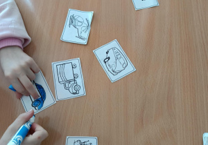 Uczniowie dopasowują flashcardy – dzieci stoją przy tablicy i dopasowują obrazki do angielskich słówek.