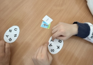 Uczniowie rozszyfrowują wielkanocne słówka w języku angielskim w formie zabawy edukacyjnej.